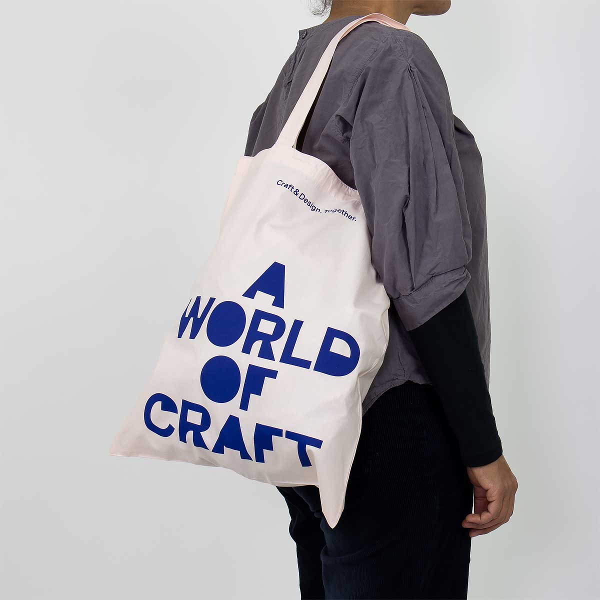 Modell vär en rutig tygpåse i rosa och blått - A World of Craft