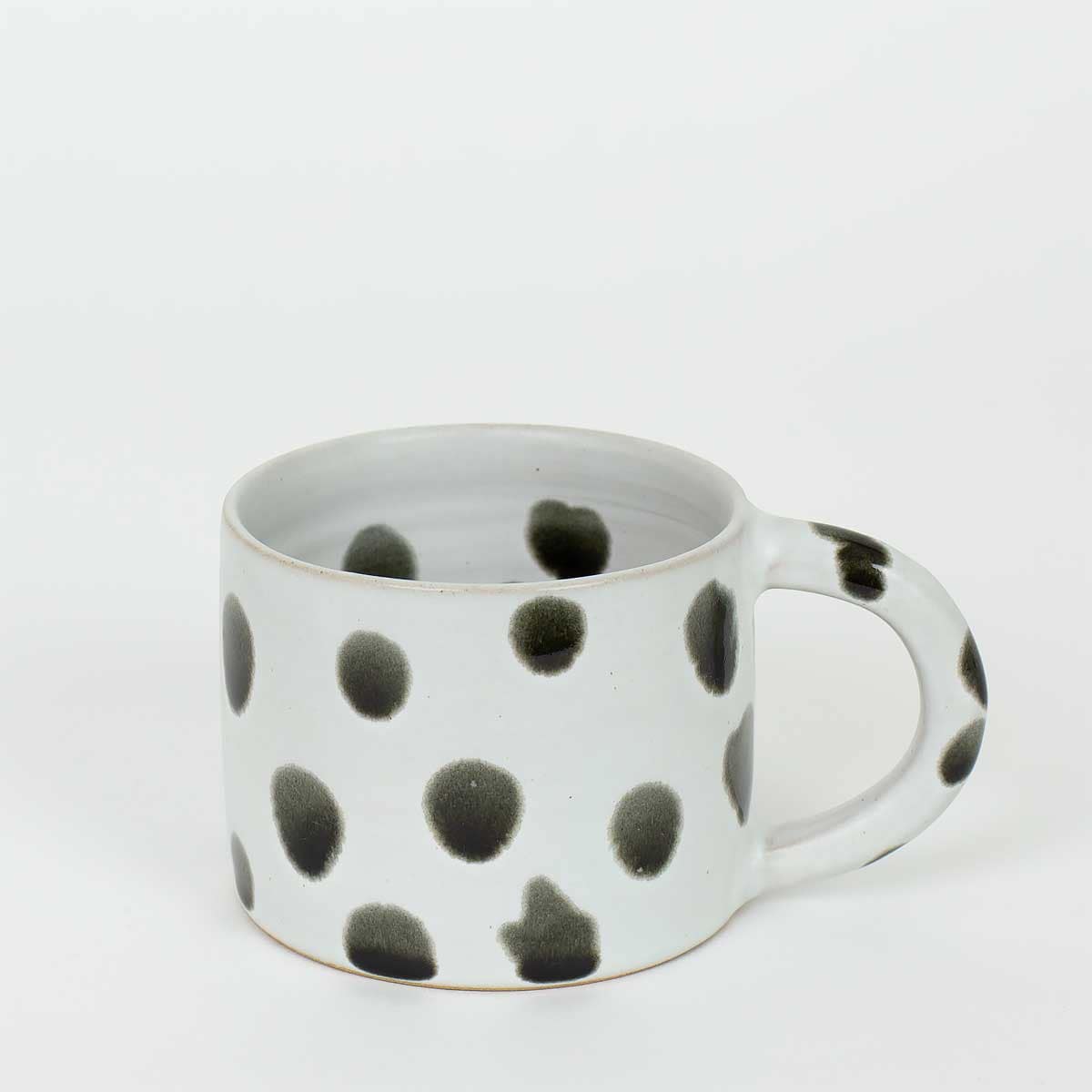 Vit kaffemugg med svarta prickar