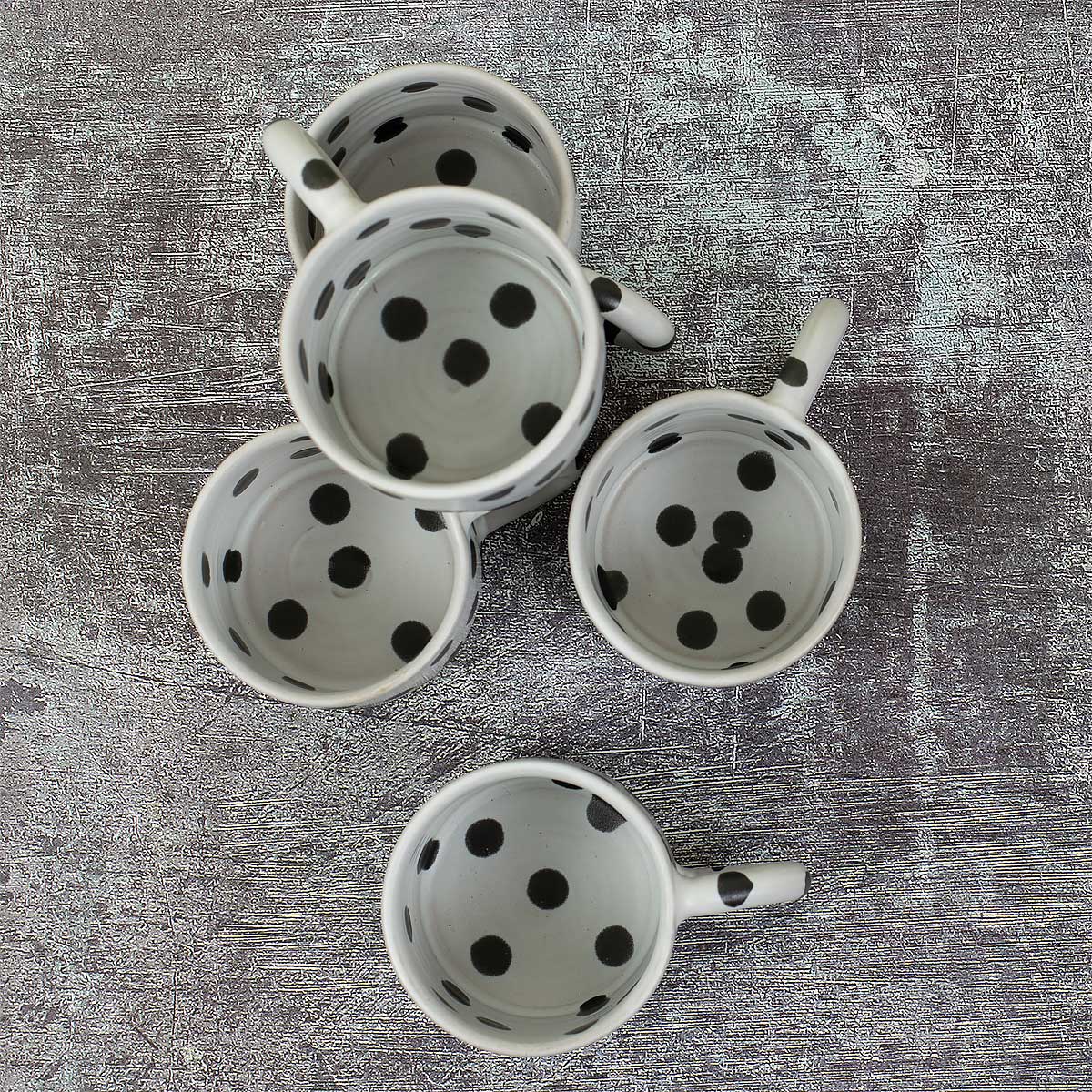 Vita kaffekoppar med svarta prickar