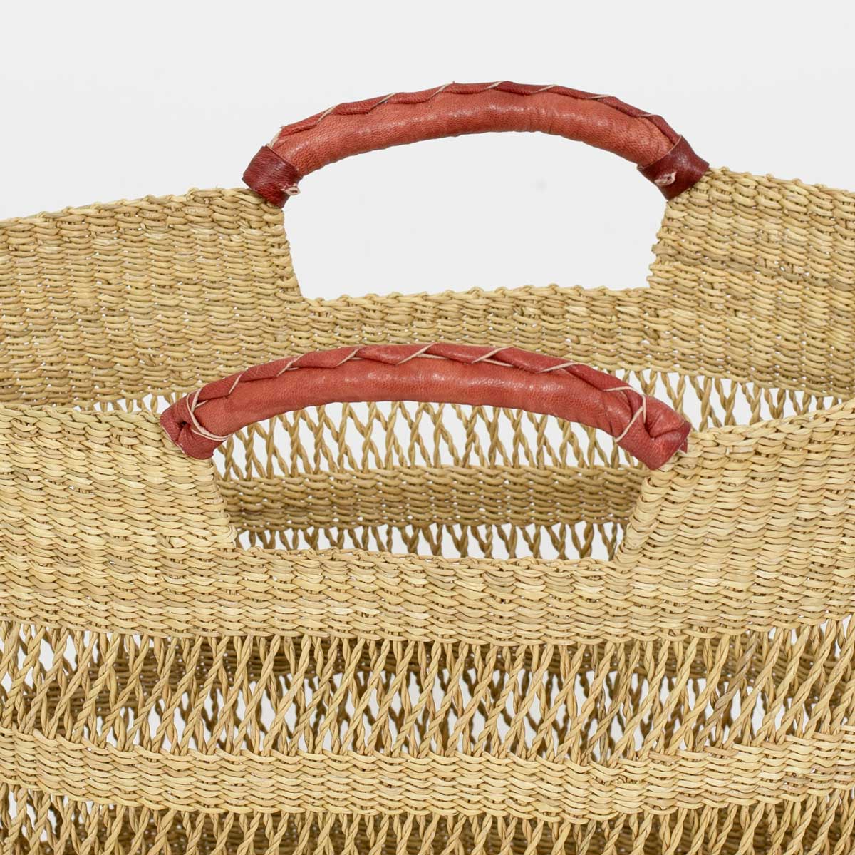 Detalj av skinnhandtag på en naturfärgad korgväska