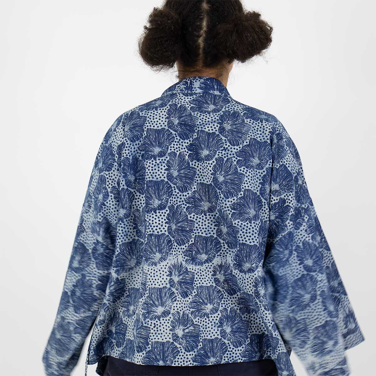 Modell bär en kort kimono med blommigt mönster i blått - Fair Trade