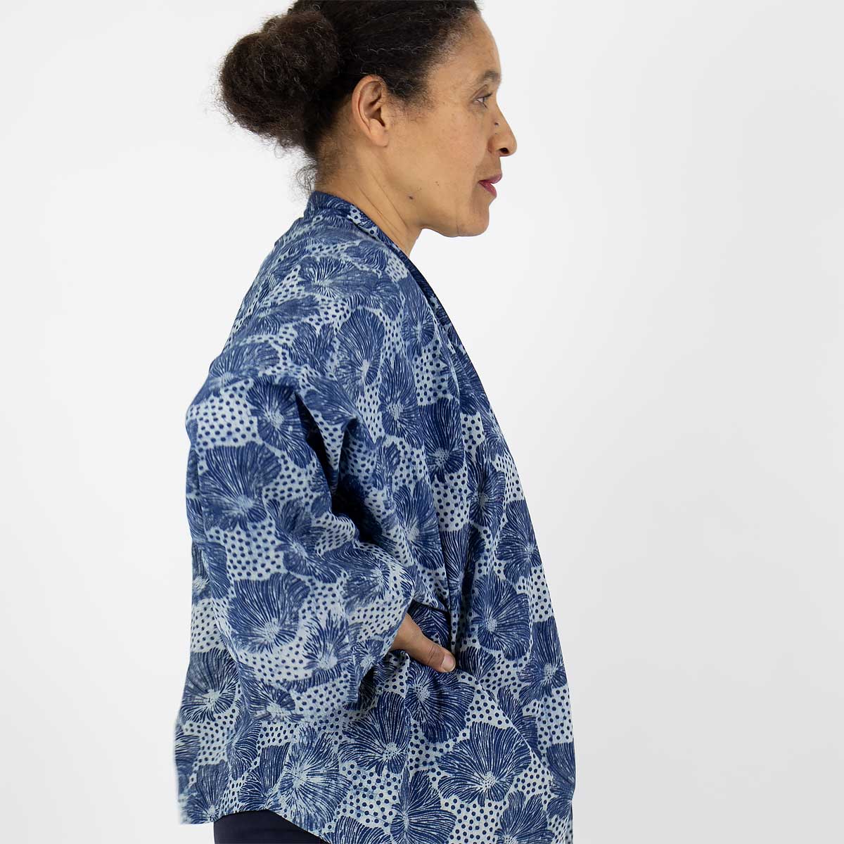 Modell bär en kort kimono med blommigt mönster i blått - Fair Trade