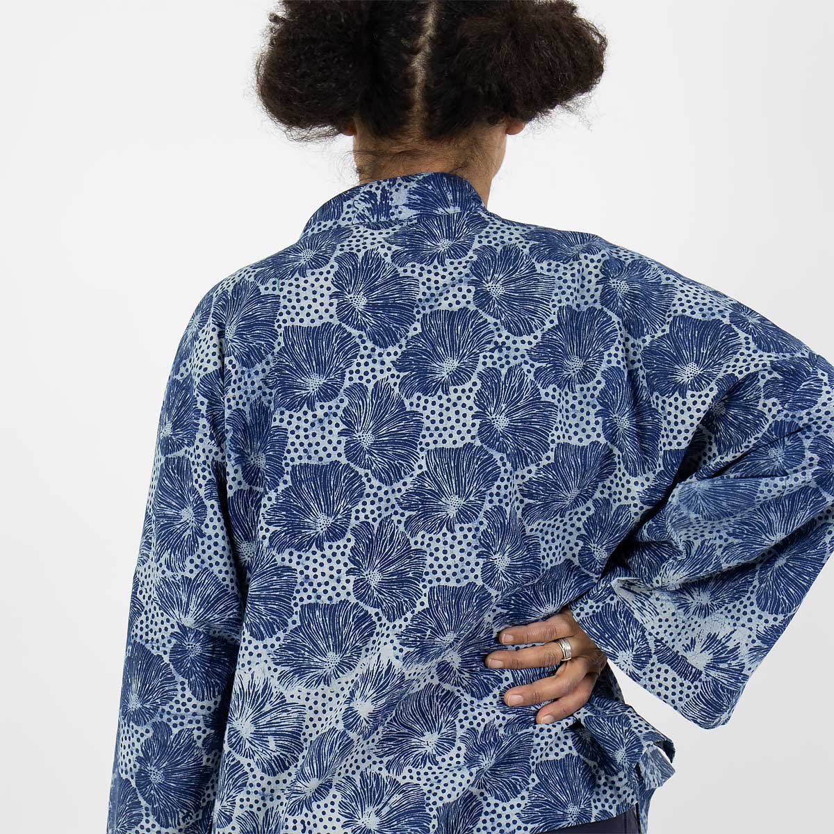 Modell bär en kort kimono med blommigt mönster i blått - Fair Trade