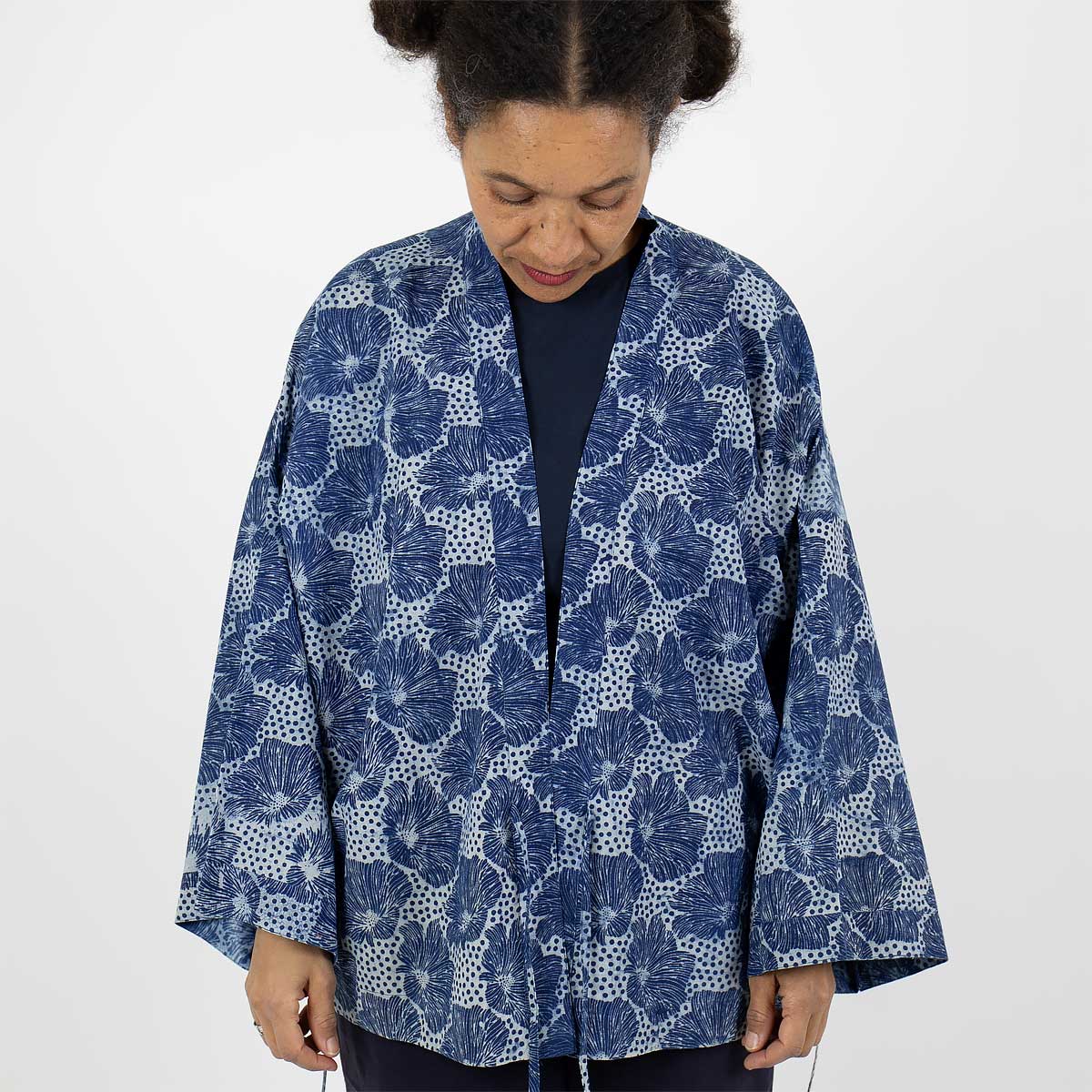 Modell bär en kort kimono med blommigt mönster i blått - Fair Trade