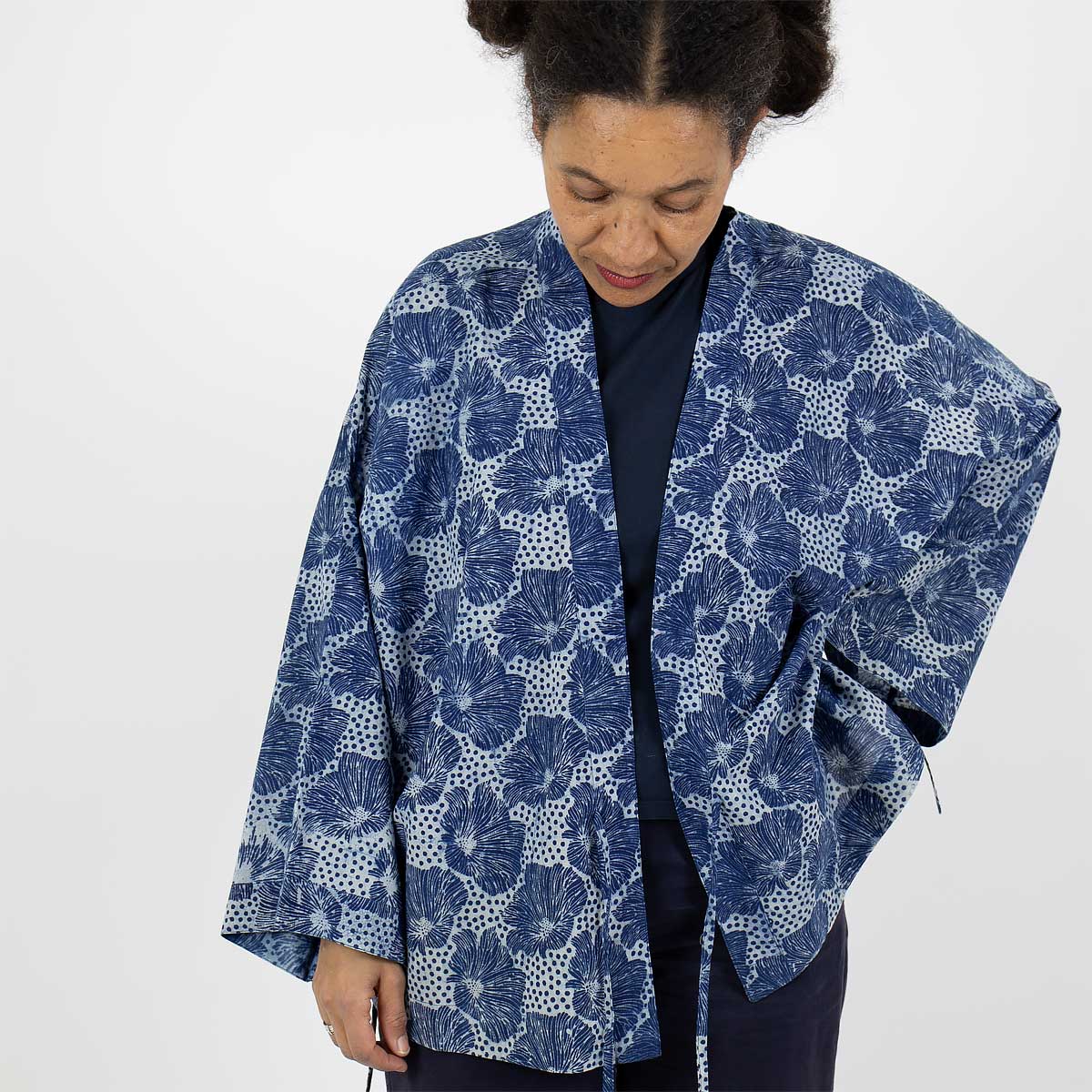 Modell bär en kort kimono med blommigt mönster i blått - Fair Trade