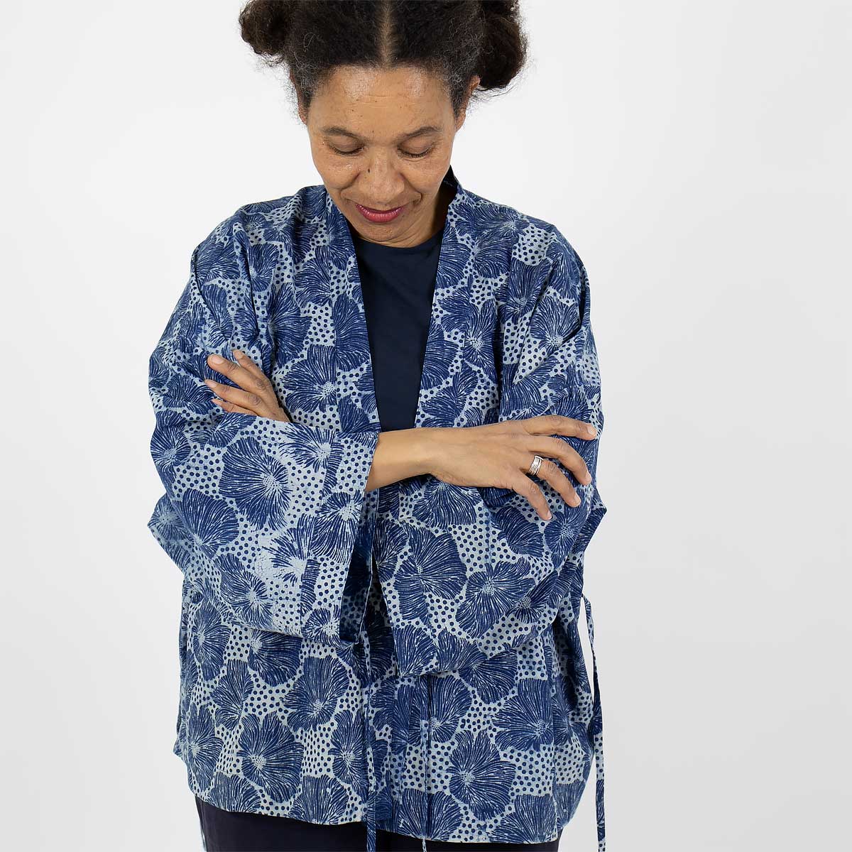 Modell bär en kort kimono med blommigt mönster i blått - Fair Trade