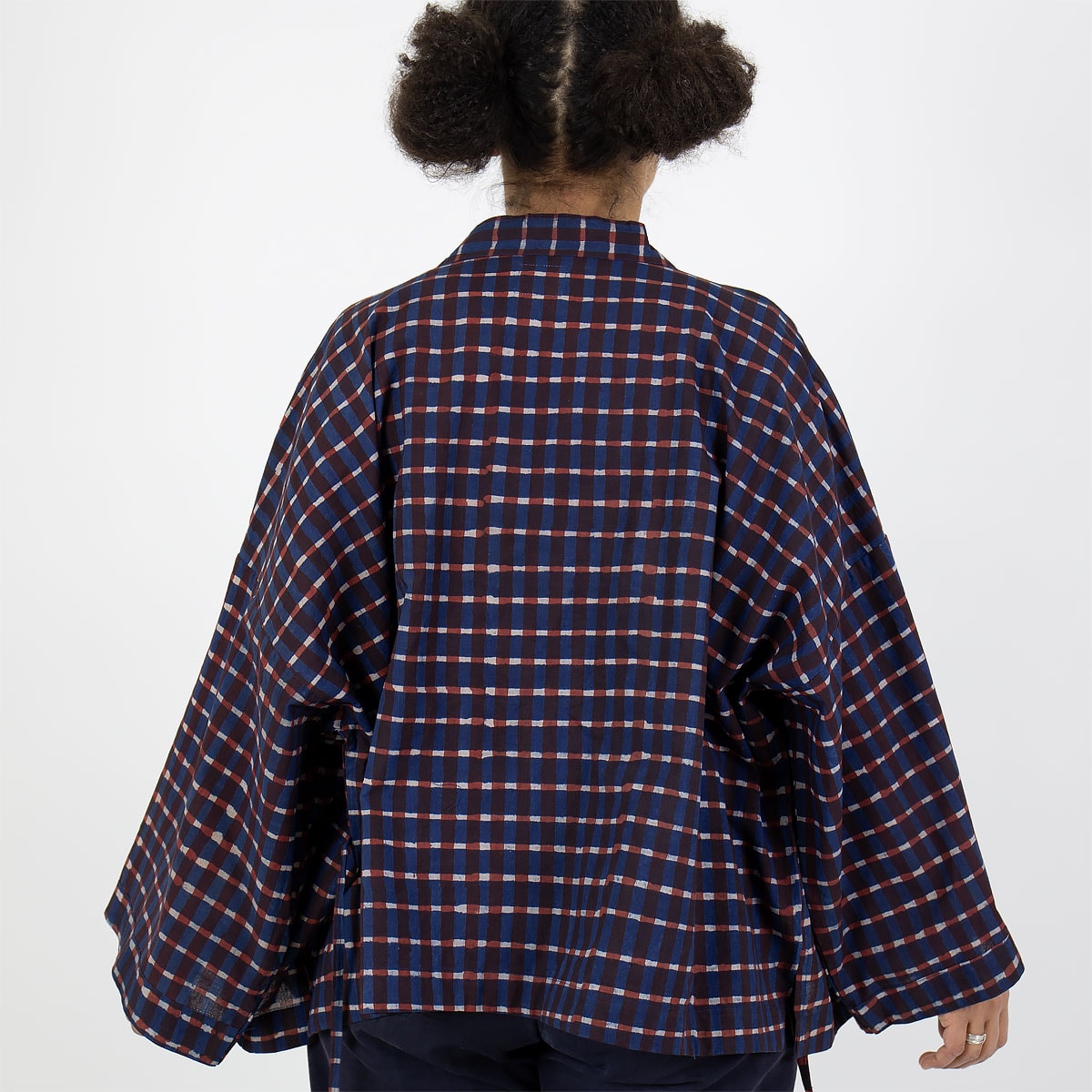 Modell bär kort kimono med rutigt mönster, i blått och rött - Fair Trade