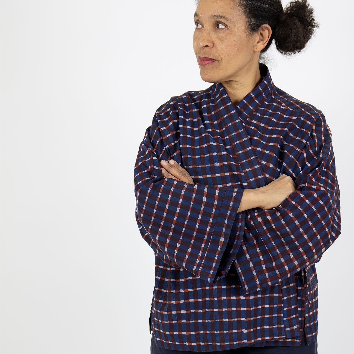 Modell bär kort kimono med rutigt mönster, i blått och rött - Fair Trade