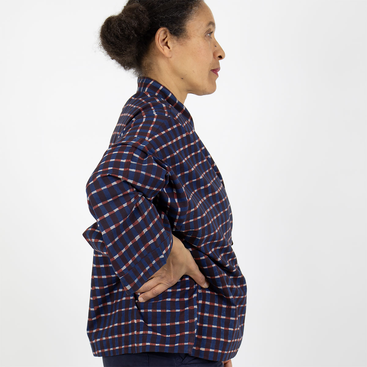 Modell bär kort kimono med rutigt mönster, i blått och rött - Fair Trade