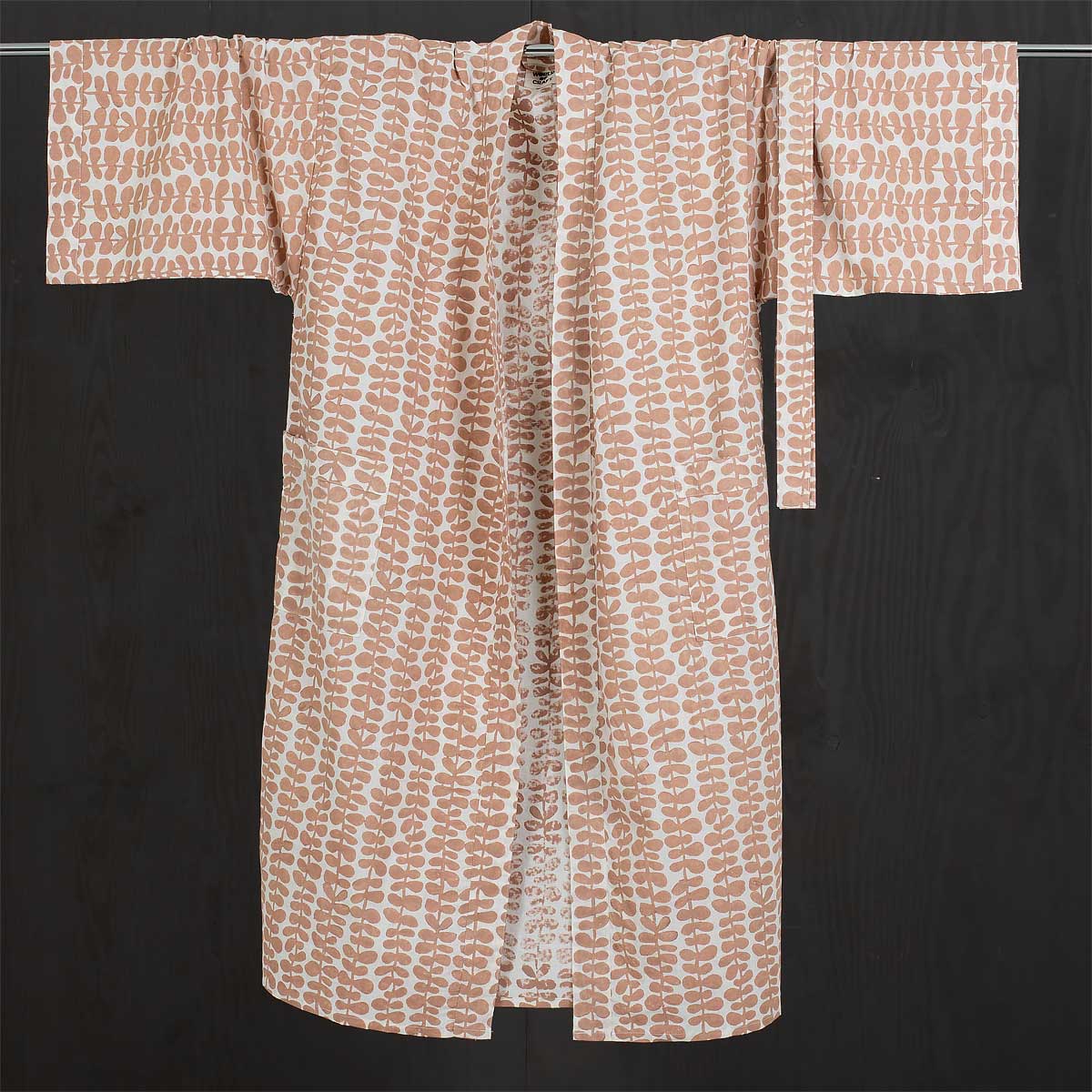 En kimono med skärp och fickor i färgerna rosa och vitt