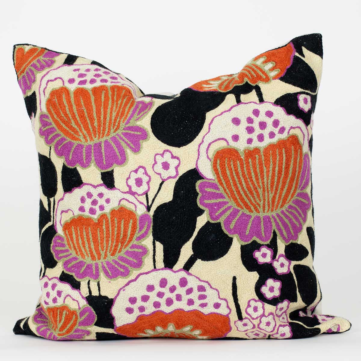 En kudde i 50x50 med stora blommor i rosa, orange och beige