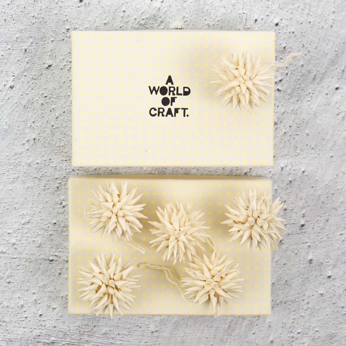 Små beige julhänge föreställande kottar