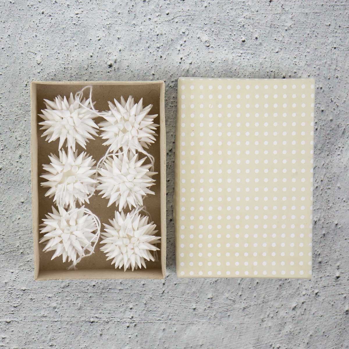 Små vita julhänge föreställande kottar