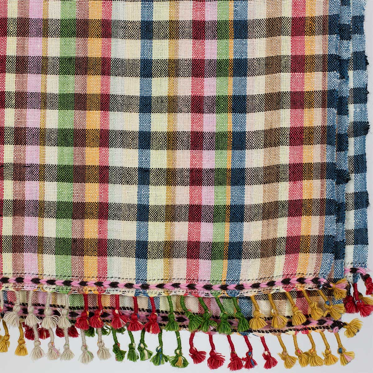 Detaljbild av rutig ullpläd i blått, beige, rött, grönt