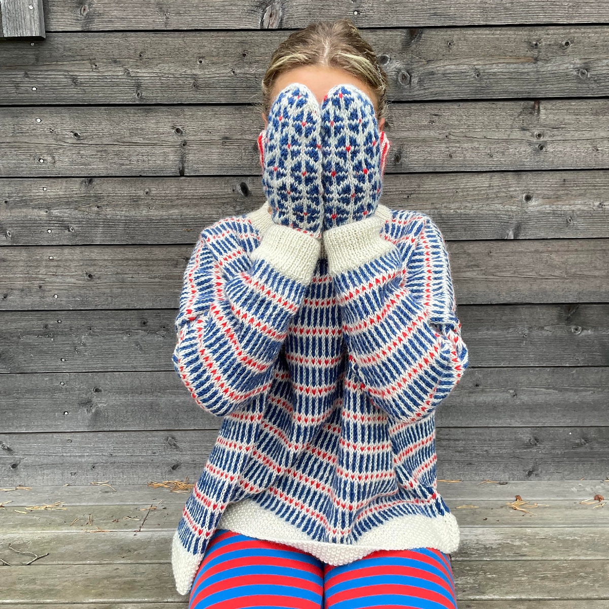 Ung tjej som har på sig en handstockad tröja i rött, blått och vitt