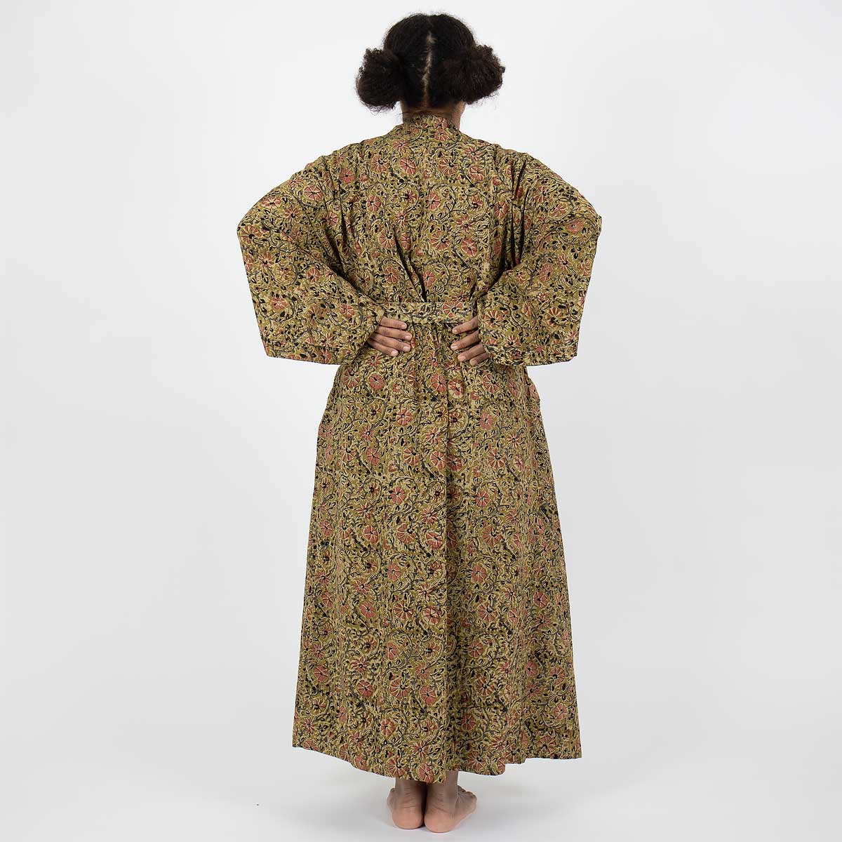Modell bär hellång kimono i senapsgult blommönster - Fair Trade