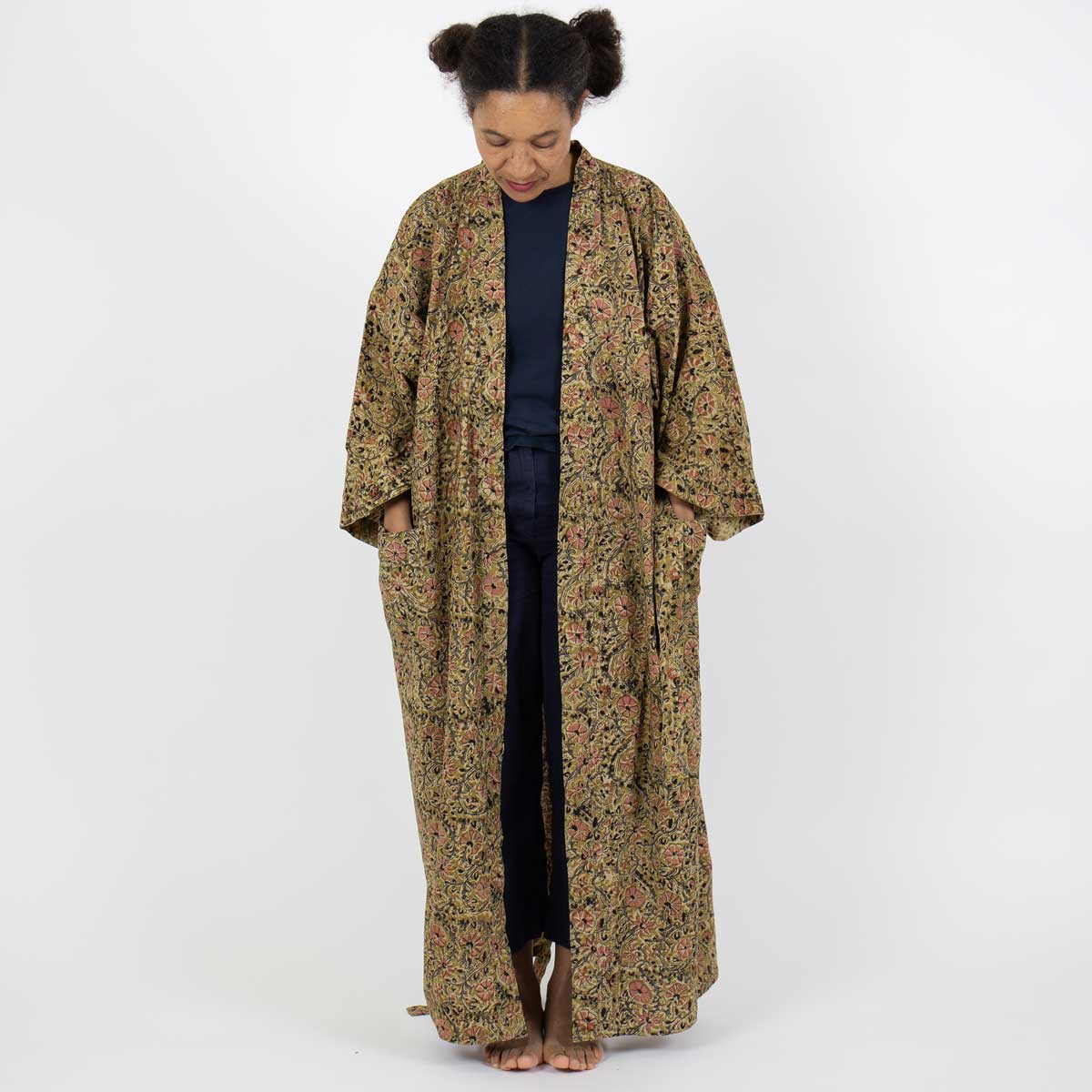 Modell bär hellång kimono i senapsgult blommönster - Fair Trade