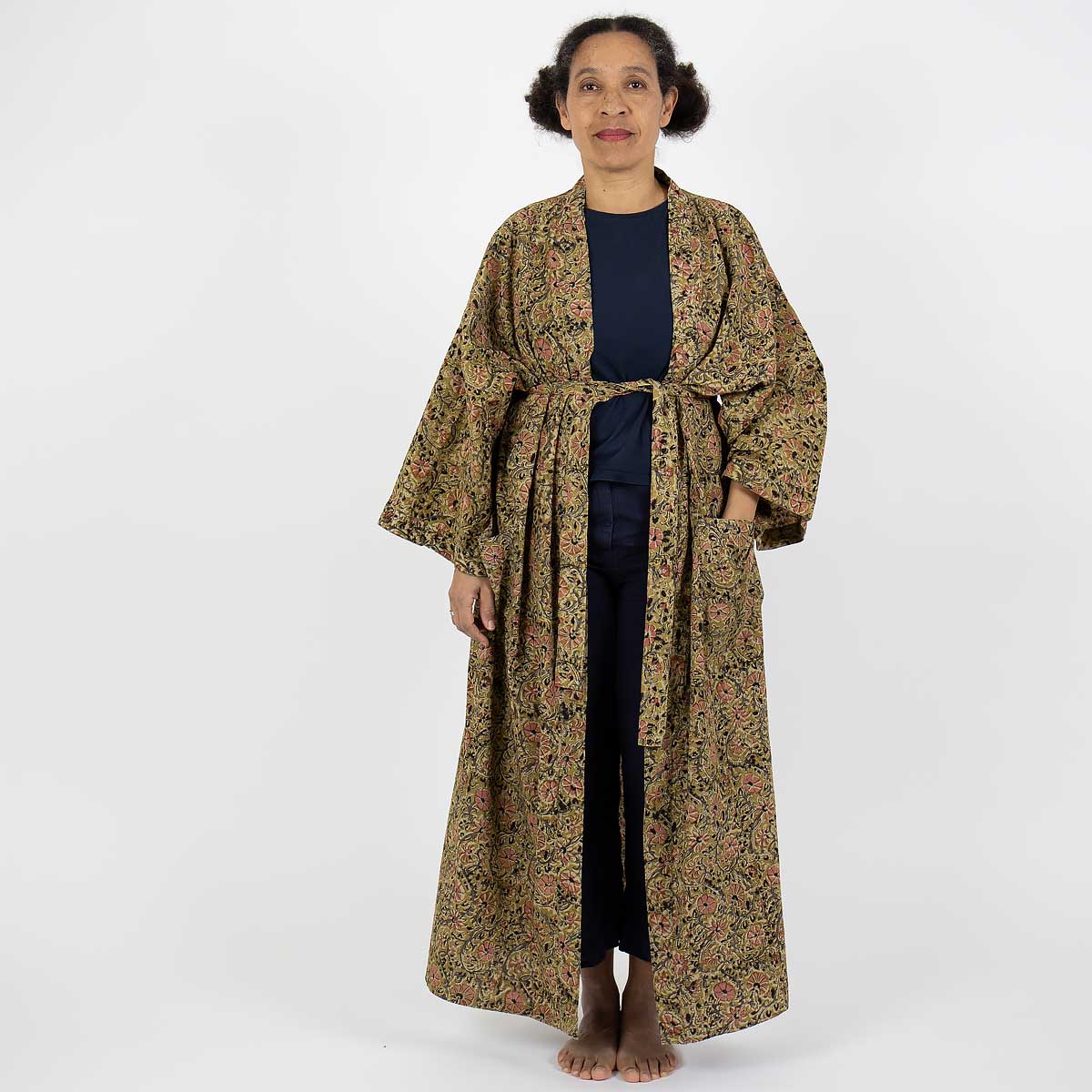 Modell bär hellång kimono i senapsgult blommönster - Fair Trade
