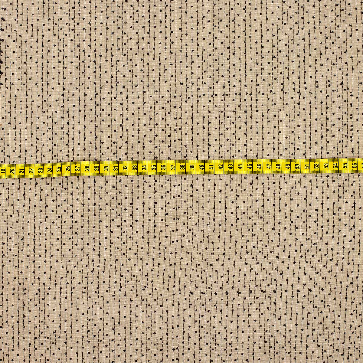 Randigt bomullstyg meed små prickar, på metervara i beige och svart