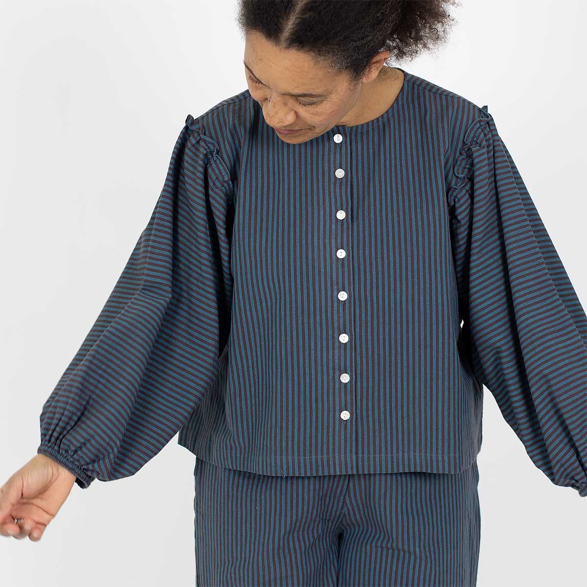Modell bär byxor och blus i blå och vit bomull - Fair Trade från Indien